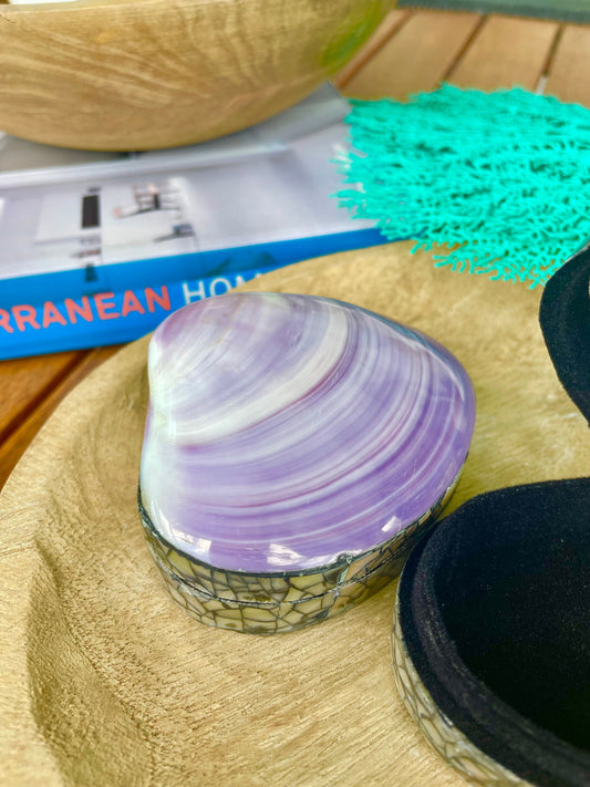 May include: A purple and white seashell jewelry box with a mosaic design. The box is open and the inside is lined with black velvet.